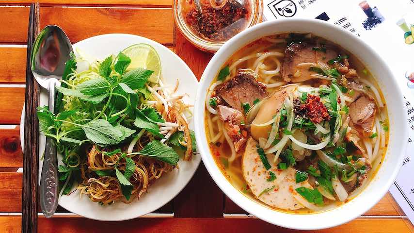 A bowl of ramen with salad on the side